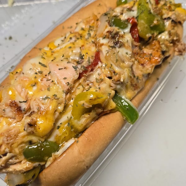 Cheesy chicken cheesesteak with peppers and onions in a clear plastic container.