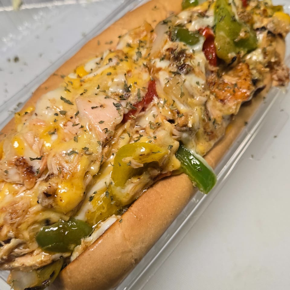 Cheesy chicken cheesesteak with peppers and onions in a clear plastic container.